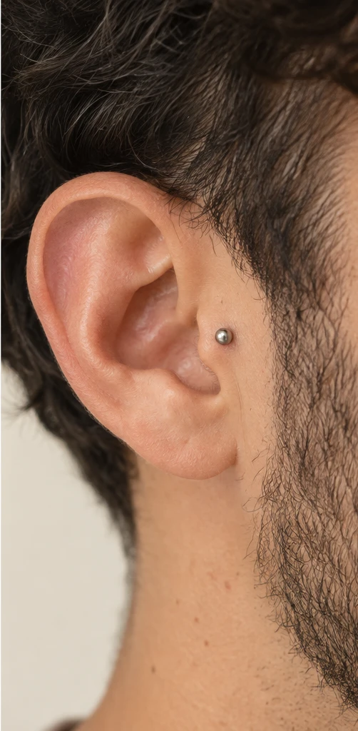 Exemplo ilustrativo de piercing tragus com joia prateada pequena
